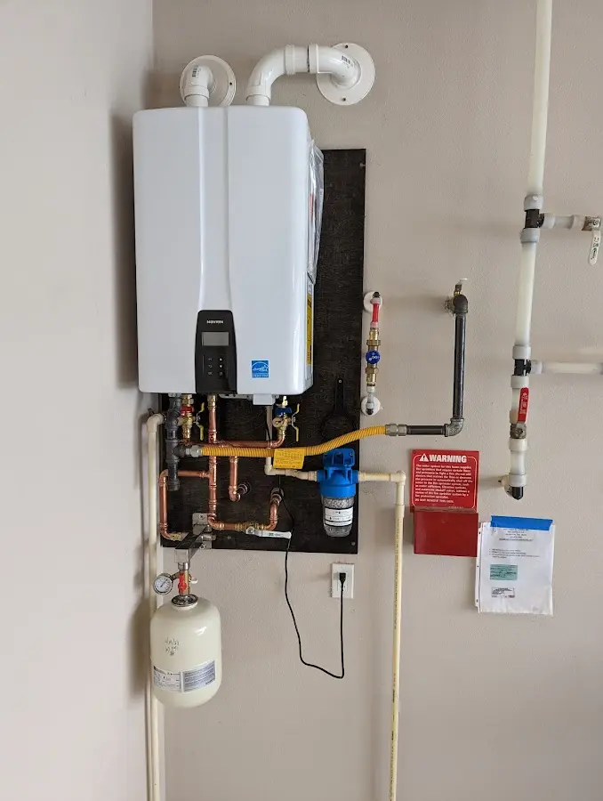 Professional plumber installing copper piping in a Rindge home